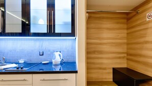 A modern bathroom with a wooden vanity, a sink, and a shower area.