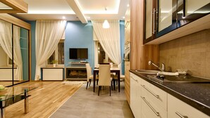 A modern kitchen with a dining area, wooden cabinets, and a black countertop.