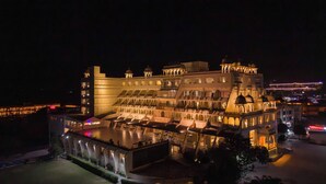 A multi-story hotel with a large pool area, multiple balconies, and traditional architectural elements. - Via Lakhela Resort & Spa (Kumbhalgarh)