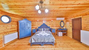 Un dormitorio tipo cabaña de madera con cama, cómoda y espejo.