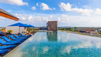 Una piscina al aire libre, sillones reclinables de piscina