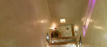 Un corridoio con pavimento piastrellato e una lampada a soffitto.