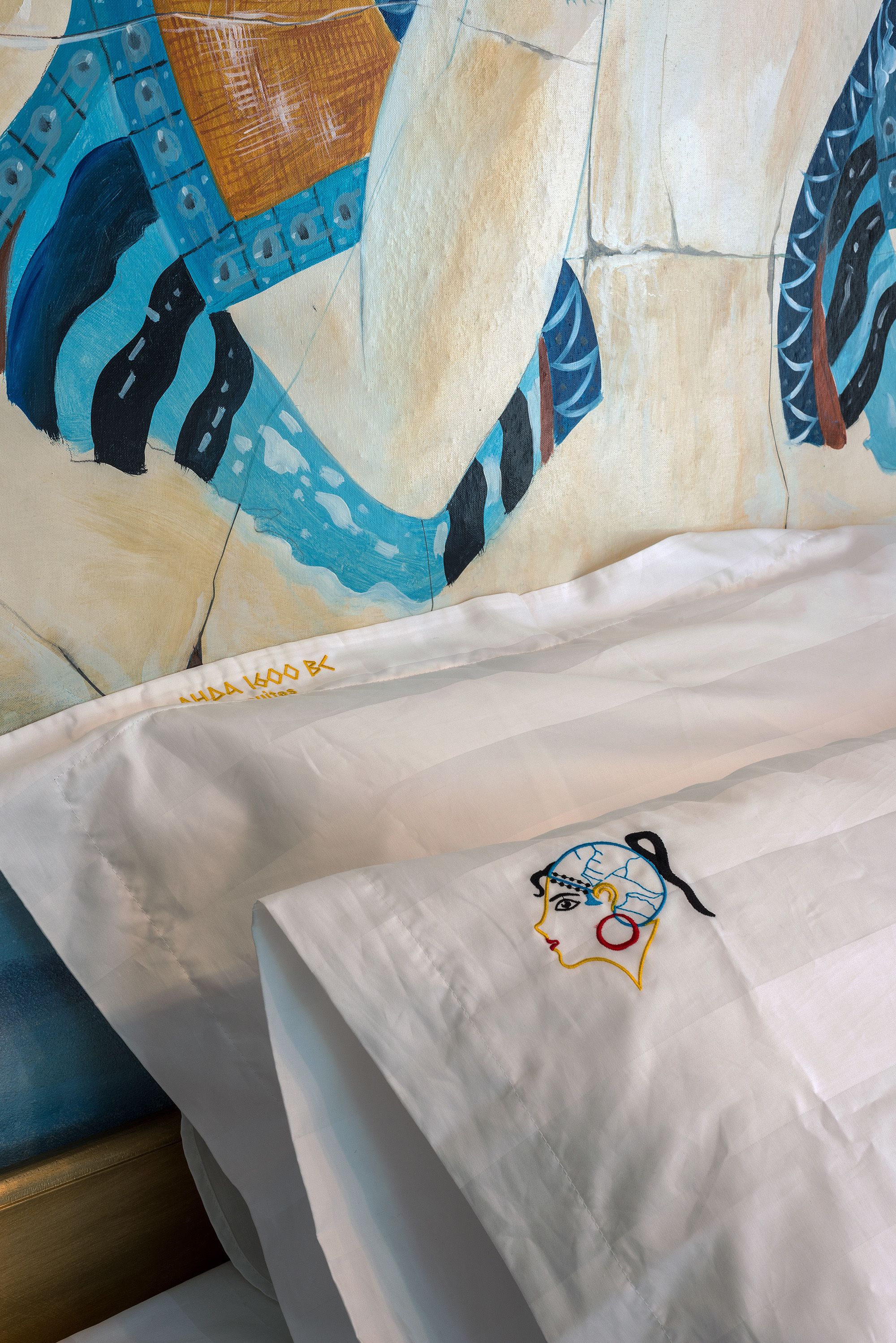 A bed with a patterned pillow and a pillow with a face design.
