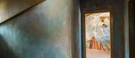 A hallway with a mural of a woman in a dress and a man in a suit.