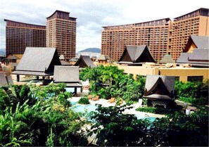 A resort with multiple high-rise buildings, a swimming pool, and lush greenery.