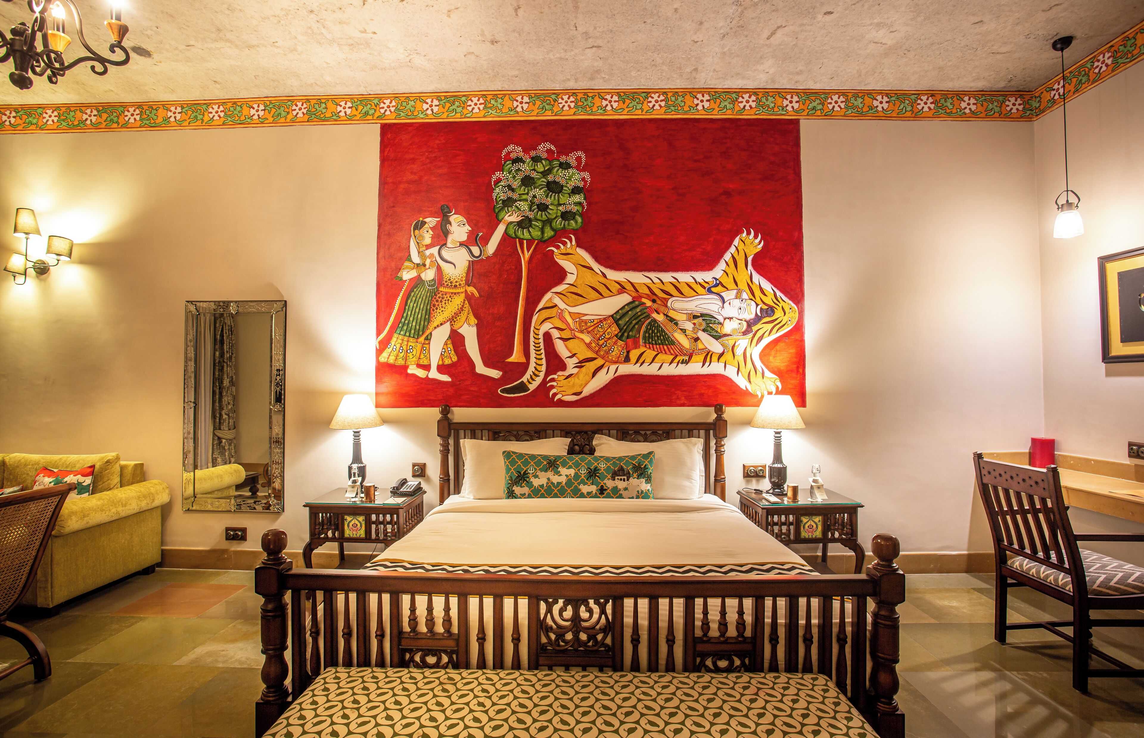 A traditional room with a bed, a mirror, a lamp, a chair, and a wall tapestry.