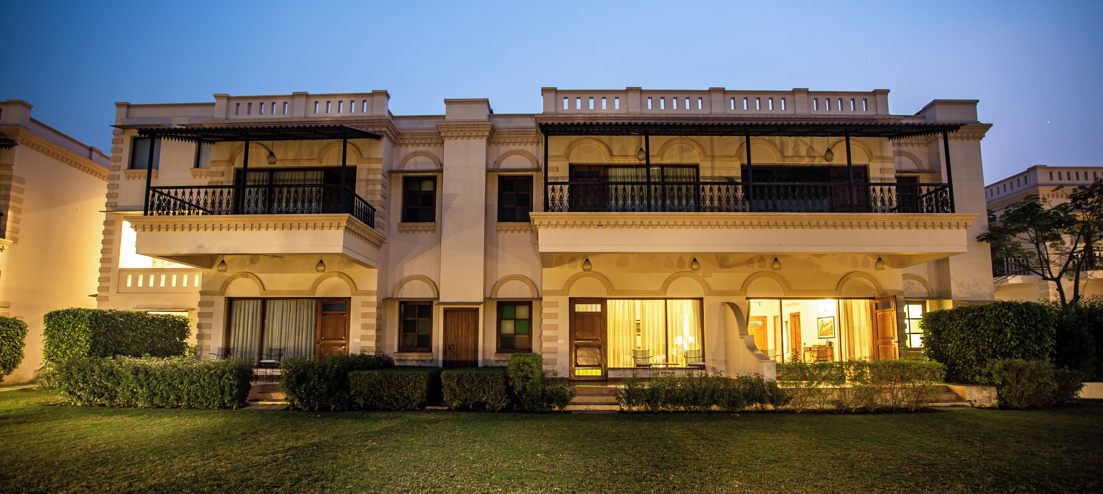 A two-story building with a symmetrical facade, large windows, and a well-maintained lawn.