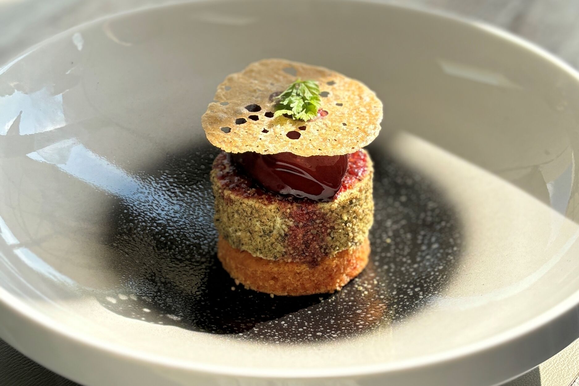 En dessert med en krispig botten, en mörk fyllning och en garnering ovanpå, serverad i en skål.