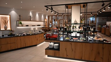 Una cocina moderna con armarios de madera, una isla central con un electrodoméstico rojo y diversos utensilios y electrodomésticos.