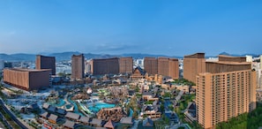 A resort with multiple buildings, a swimming pool, and a mountainous backdrop.