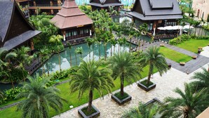 Een resort met meerdere gebouwen, een centraal gelegen zwembad en verzorgde palmstruiken.