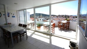 A bright room with a large window, a dining table, and chairs.