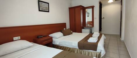 Quarto de hotel com duas camas, uma mesinha de cabeceira, um espelho e um quadro na parede.