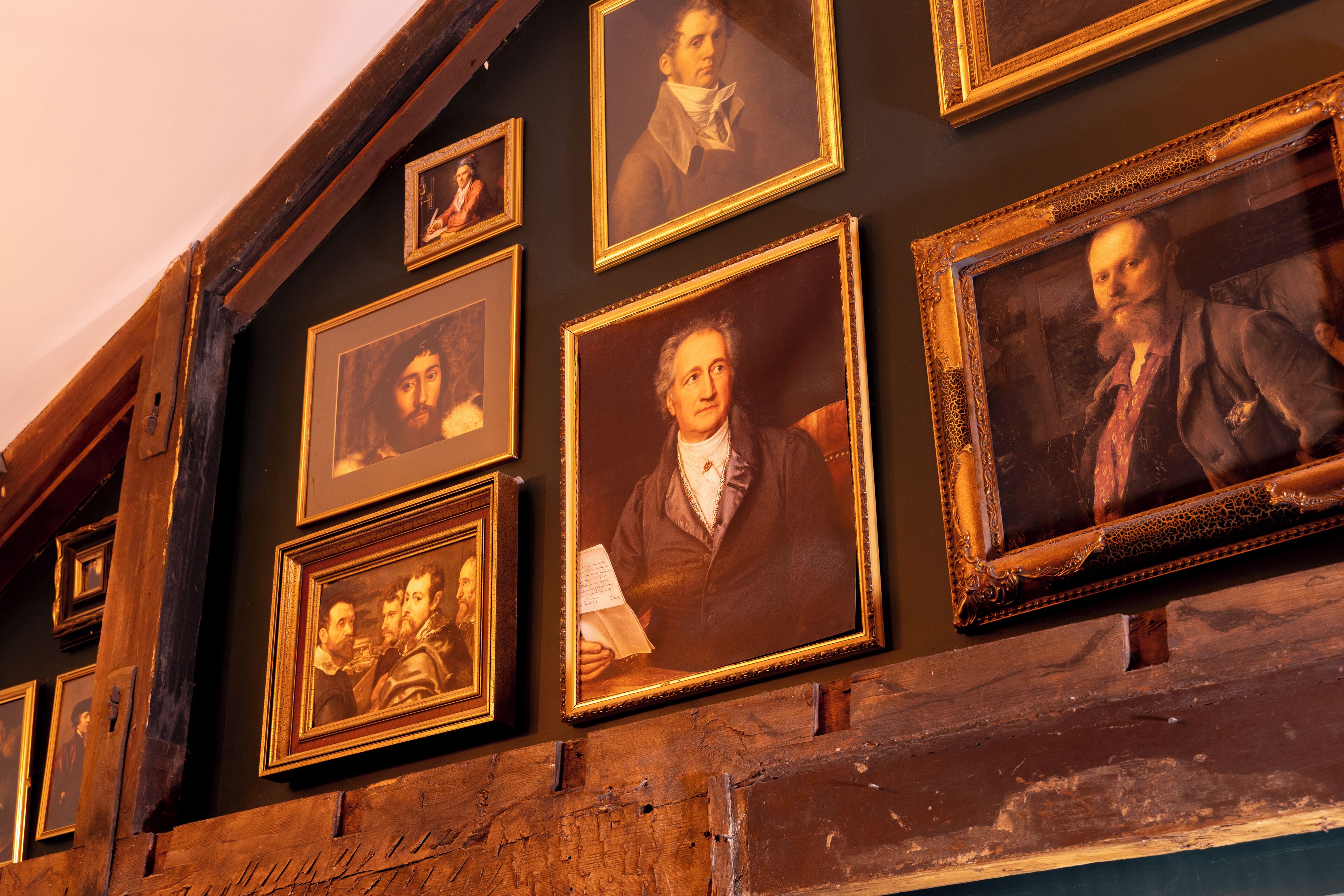 A wall with multiple framed portraits.