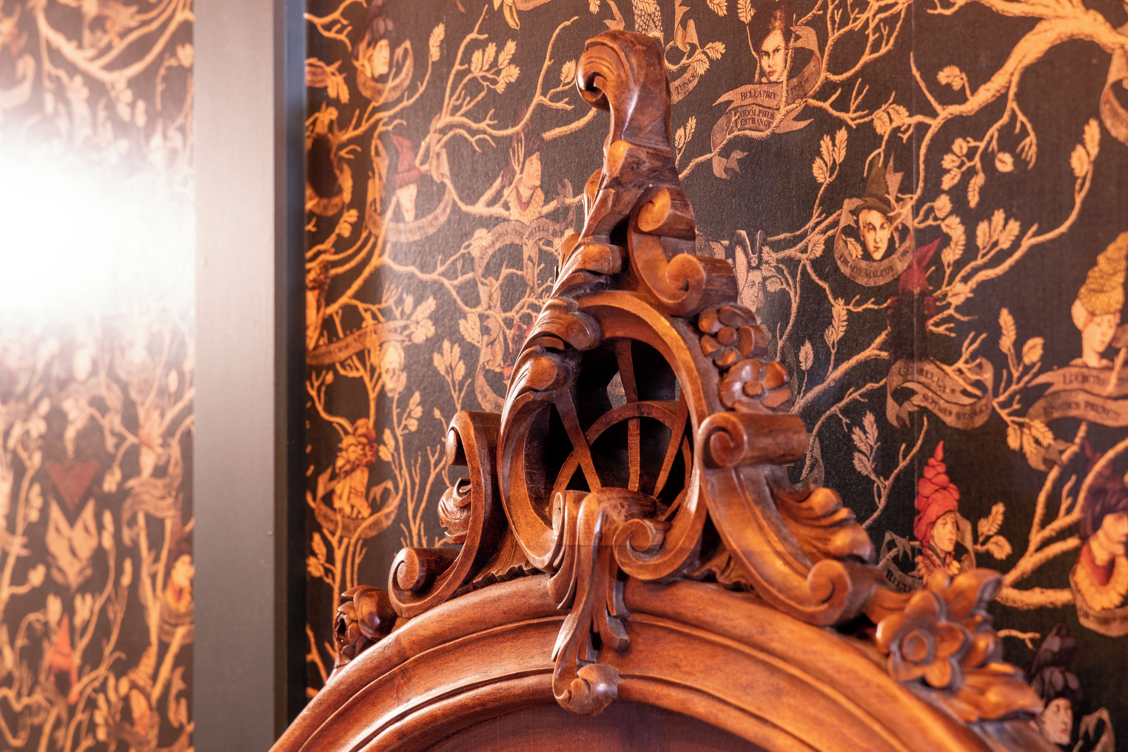 Una detallada talla de madera con diseños intrincados y un fondo oscuro con motivos.