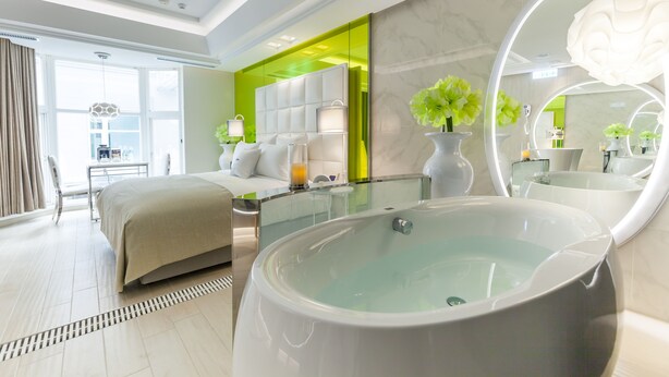 A modern hotel room with a large bed, a glass-enclosed seating area, a large mirror, and a bathtub. - Six Star Motel - Taoyuan (Taoyuan City)