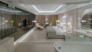A modern hotel room with a large bed, a desk, a chair, a TV, and a bathroom with a bathtub and mirror. - Six Star Motel - Taoyuan (Taoyuan City)