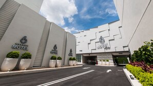 A modern motel with a clean, geometric facade and multiple signs indicating the presence of several motel units. - Six Star Motel - Taoyuan (Taoyuan City)