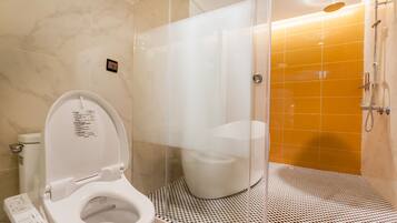 Un baño moderno con inodoro, cabina de ducha y suelo estampado.