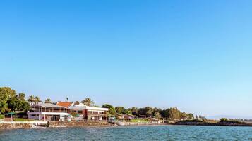 A waterfront property with a large building, a dock, and a clear blue sky.