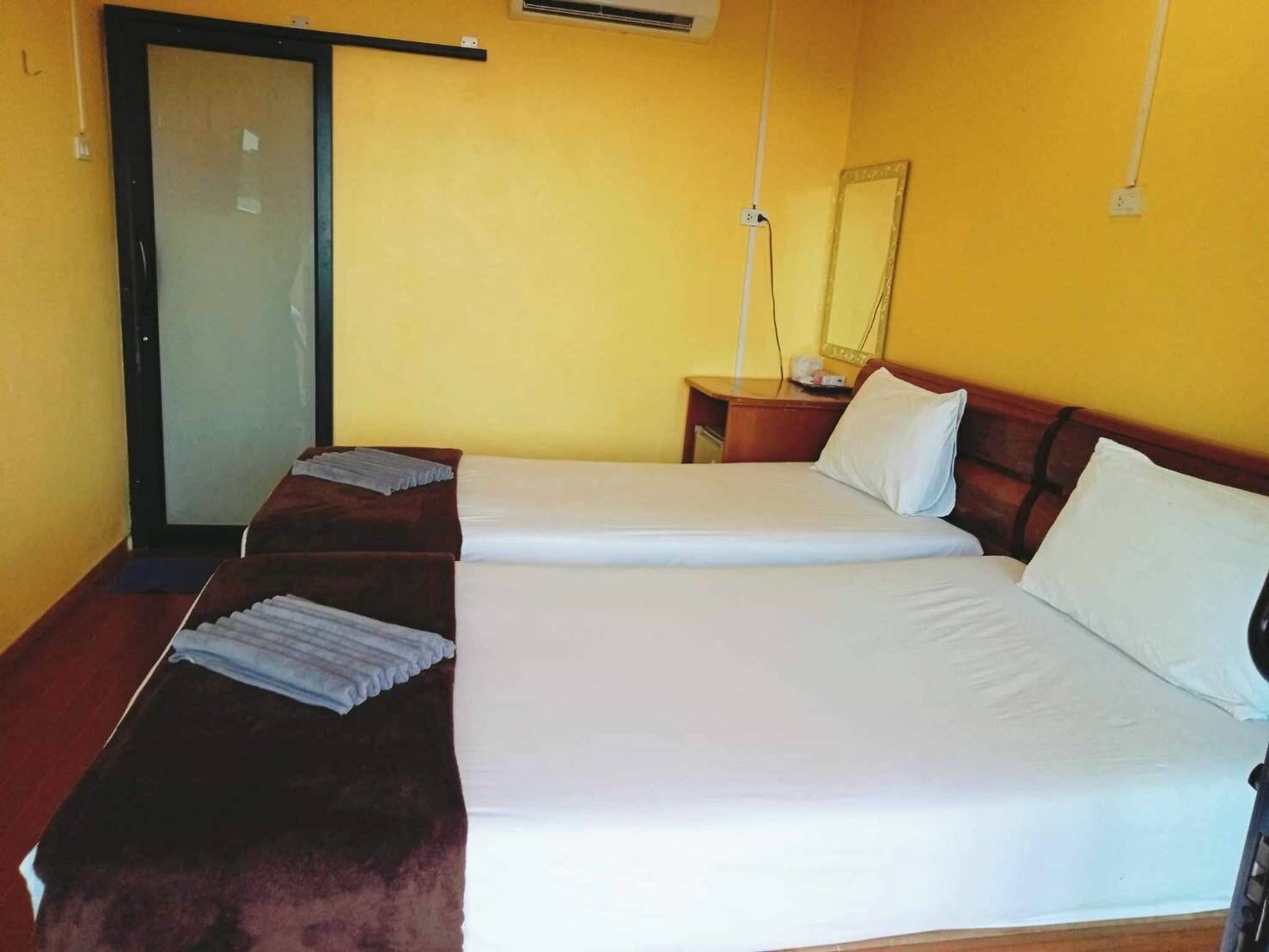 Une chambre d’hôtel avec un lit, un bureau, une chaise et une porte coulissante.