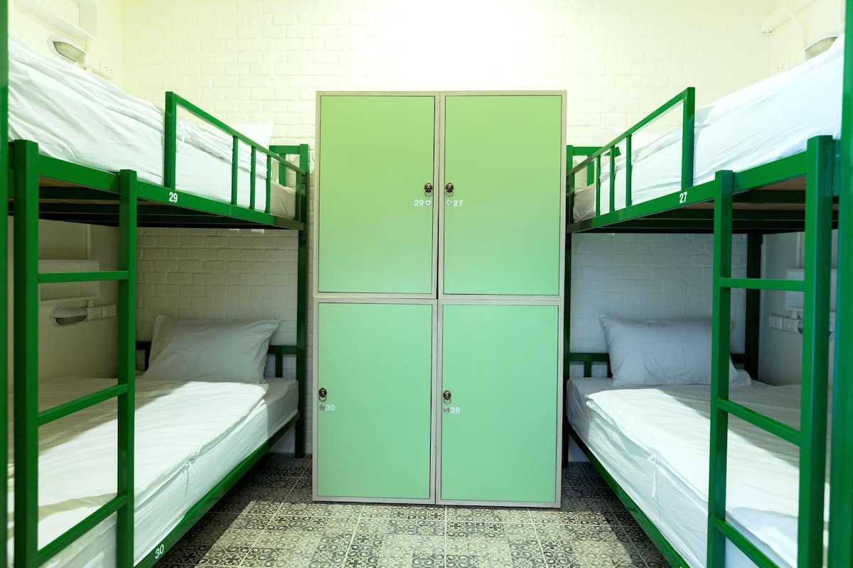 Un dormitorio con literas y un armario central.