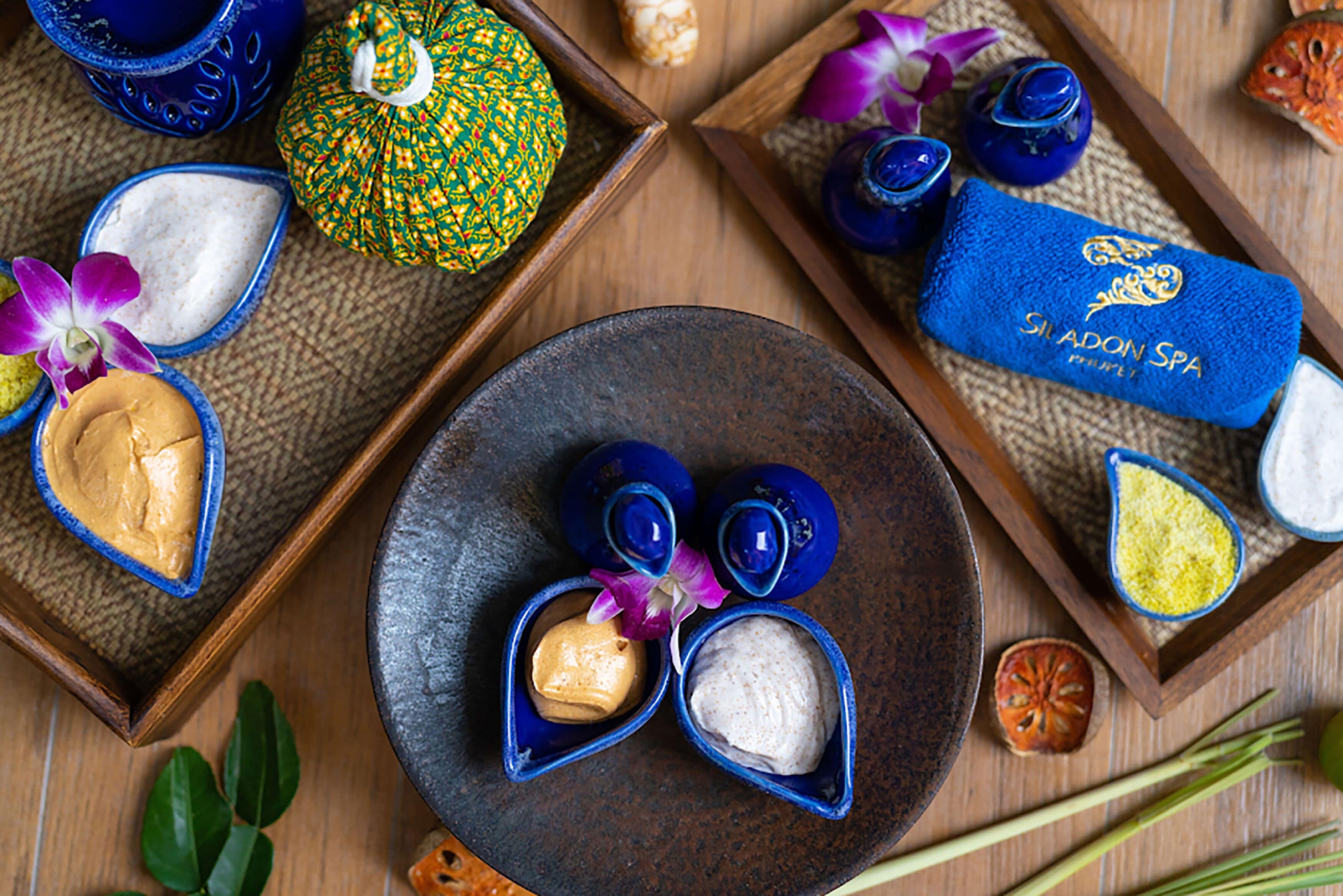 A tray with various spa products, including bowls of lotions and a blue towel with the spa's name.