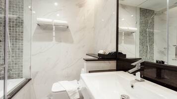 A modern bathroom with a large mirror, a bathtub, and a shower area.