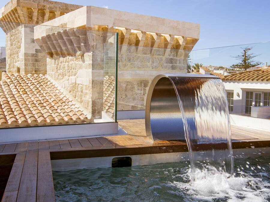 Una piscina al aire libre, sombrillas, tumbonas