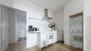 Eine moderne Küche mit weißen Schränken, einer Edelstahl-Dunstabzugshaube und einer Vitrine.