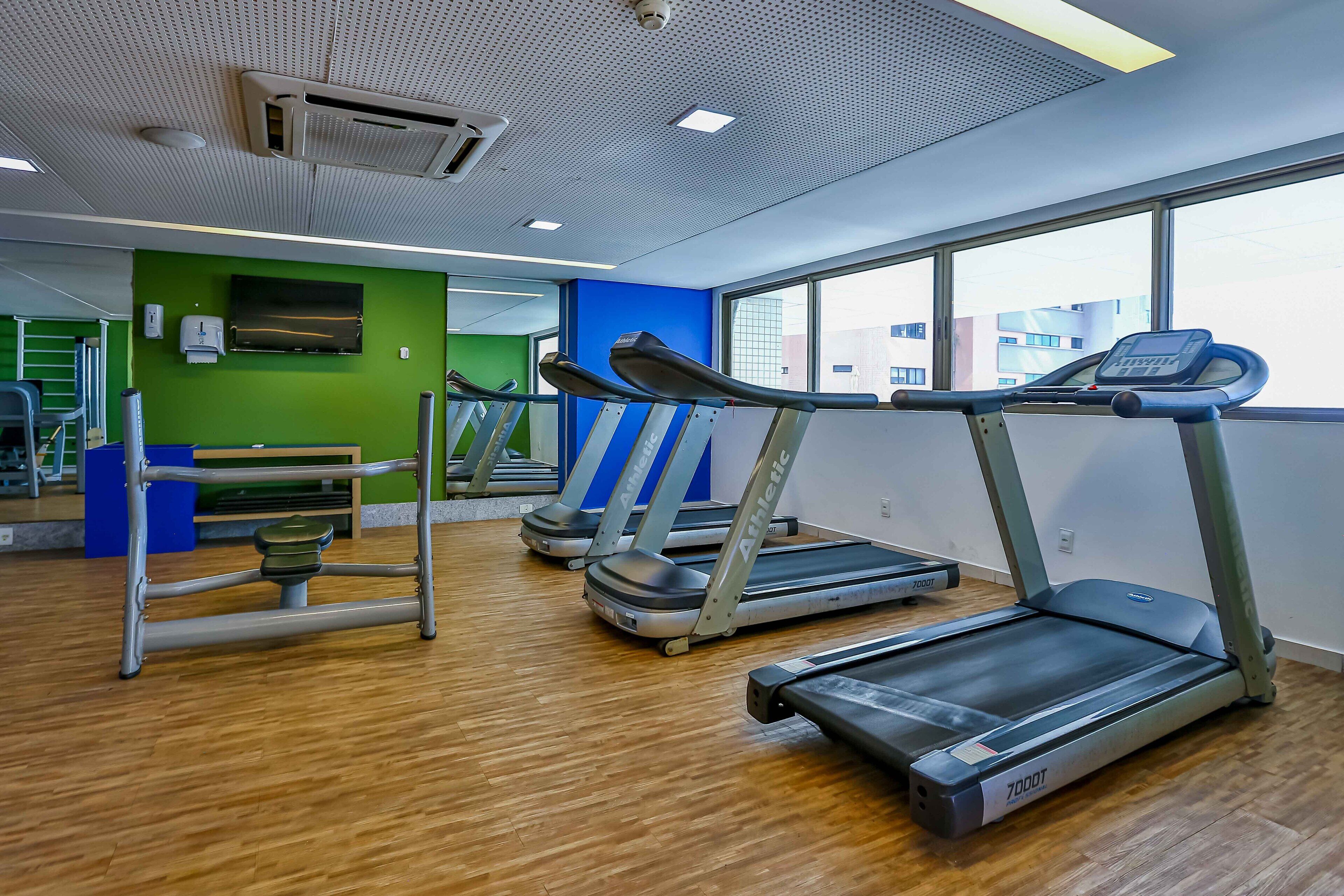 A gym with treadmills, a stationary bike, and a rowing machine.