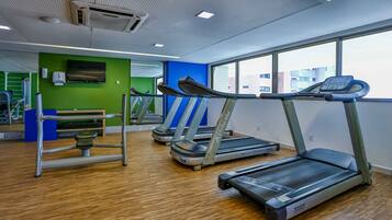 A gym with treadmills, a stationary bike, and a rowing machine.