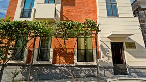 Un immeuble à plusieurs étages, doté d’une façade en briques, de balcons et surplombant un ciel dégagé.
