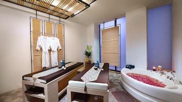 Relax in a serene space with a massage table and a spacious bathtub.