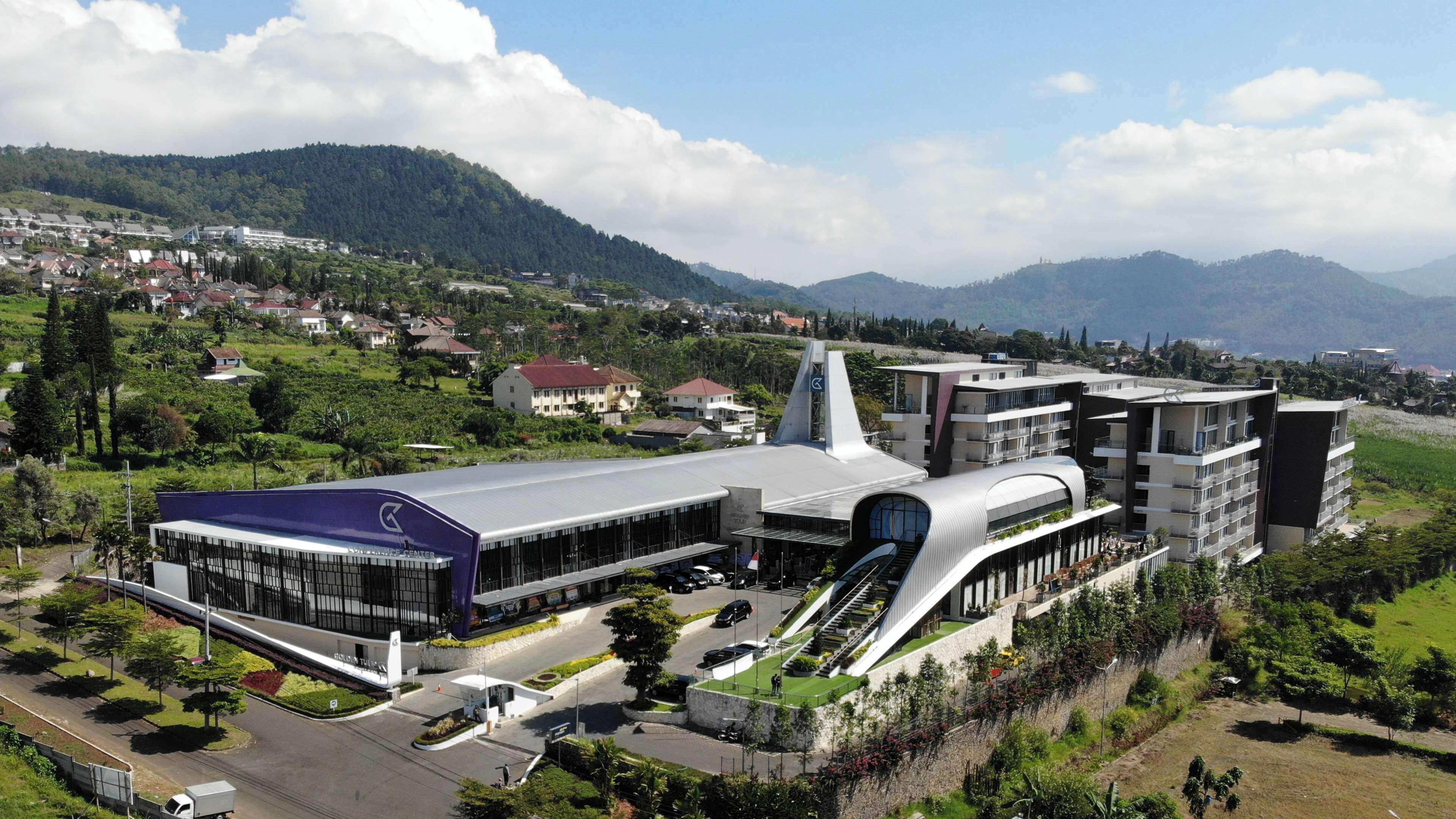 A modern building with a unique architectural design, featuring a prominent curved structure and a central tower.