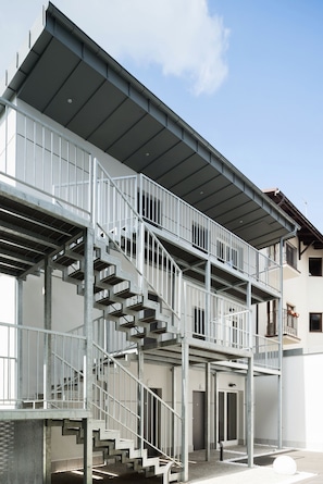 A multi-story building with a metal staircase and balcony.