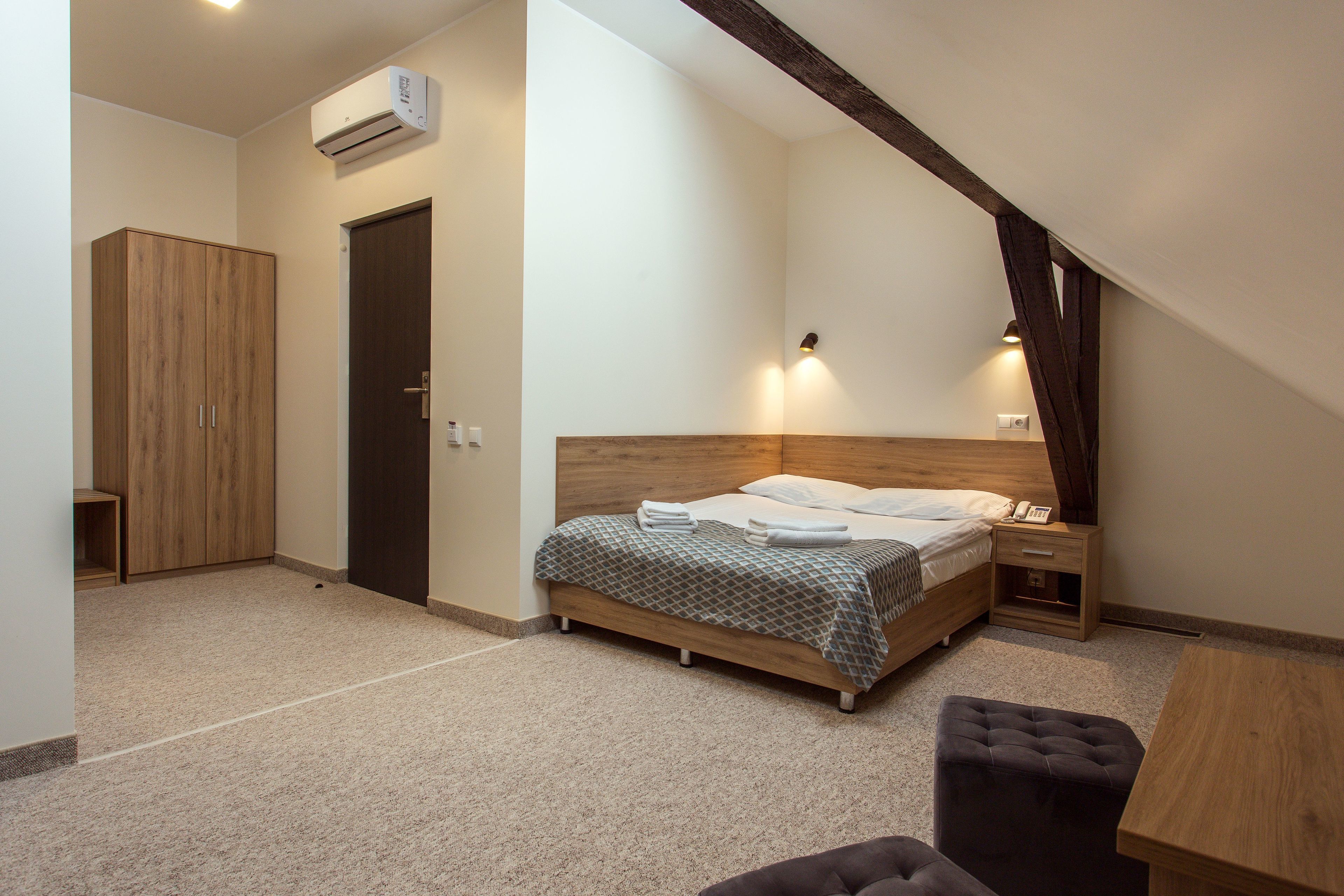 Een slaapkamer met een bed, nachtkastje en een kledingkast.
