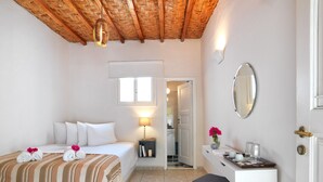 A hotel room with a bed, bedside table, and a desk with a mirror. - Thalasea Kimolos (Kimolos)