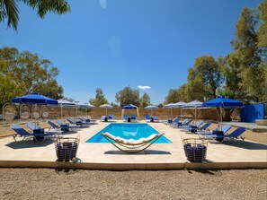 Piscine extérieure, parasols de plage, chaises longues