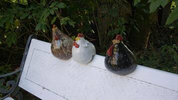 Three ceramic chickens on a white bench.