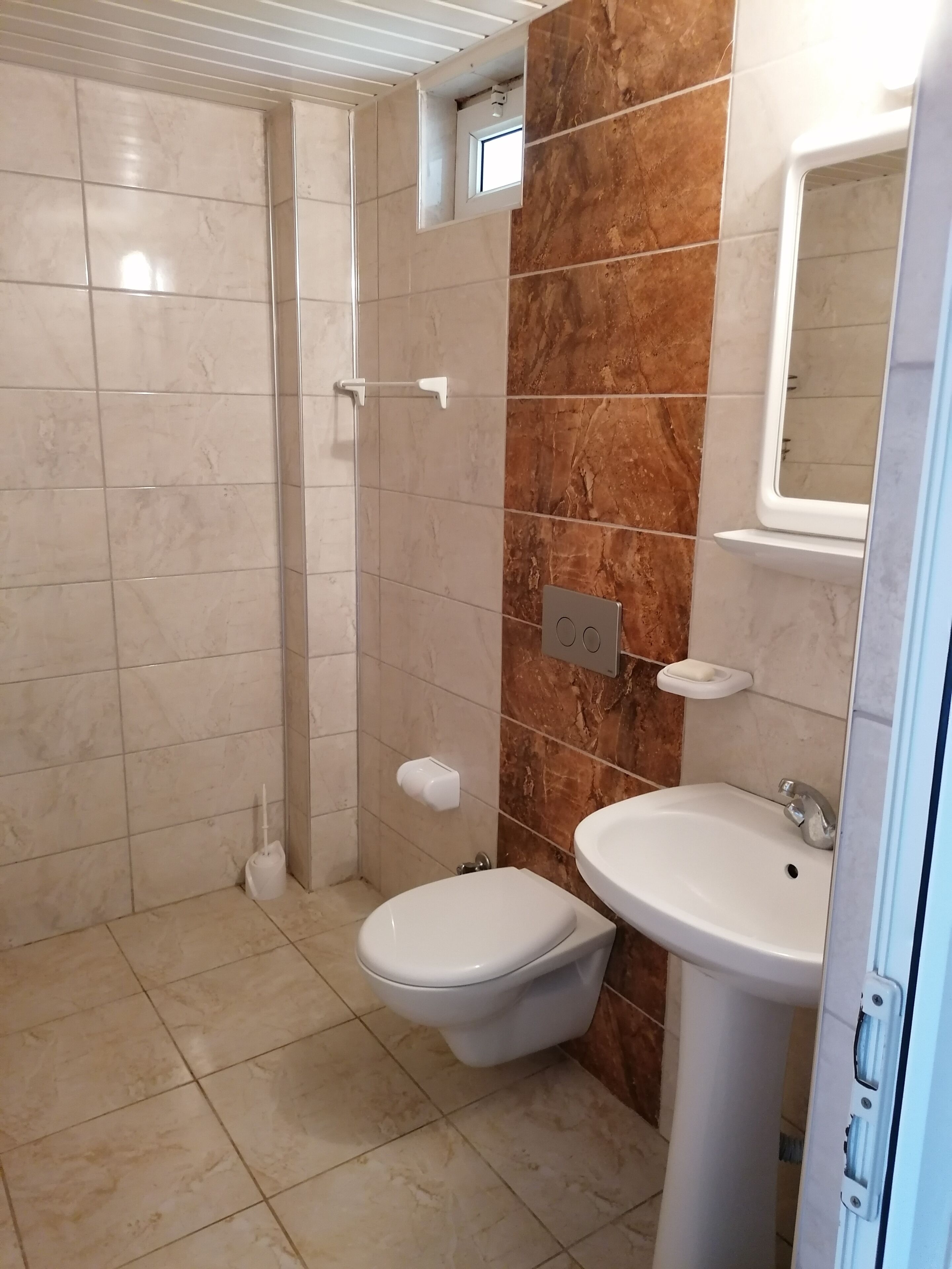 Un baño con inodoro, lavabo y cabina de ducha.