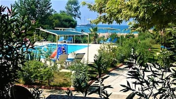 Piscine extérieure, piscine avec cascade, parasols de plage