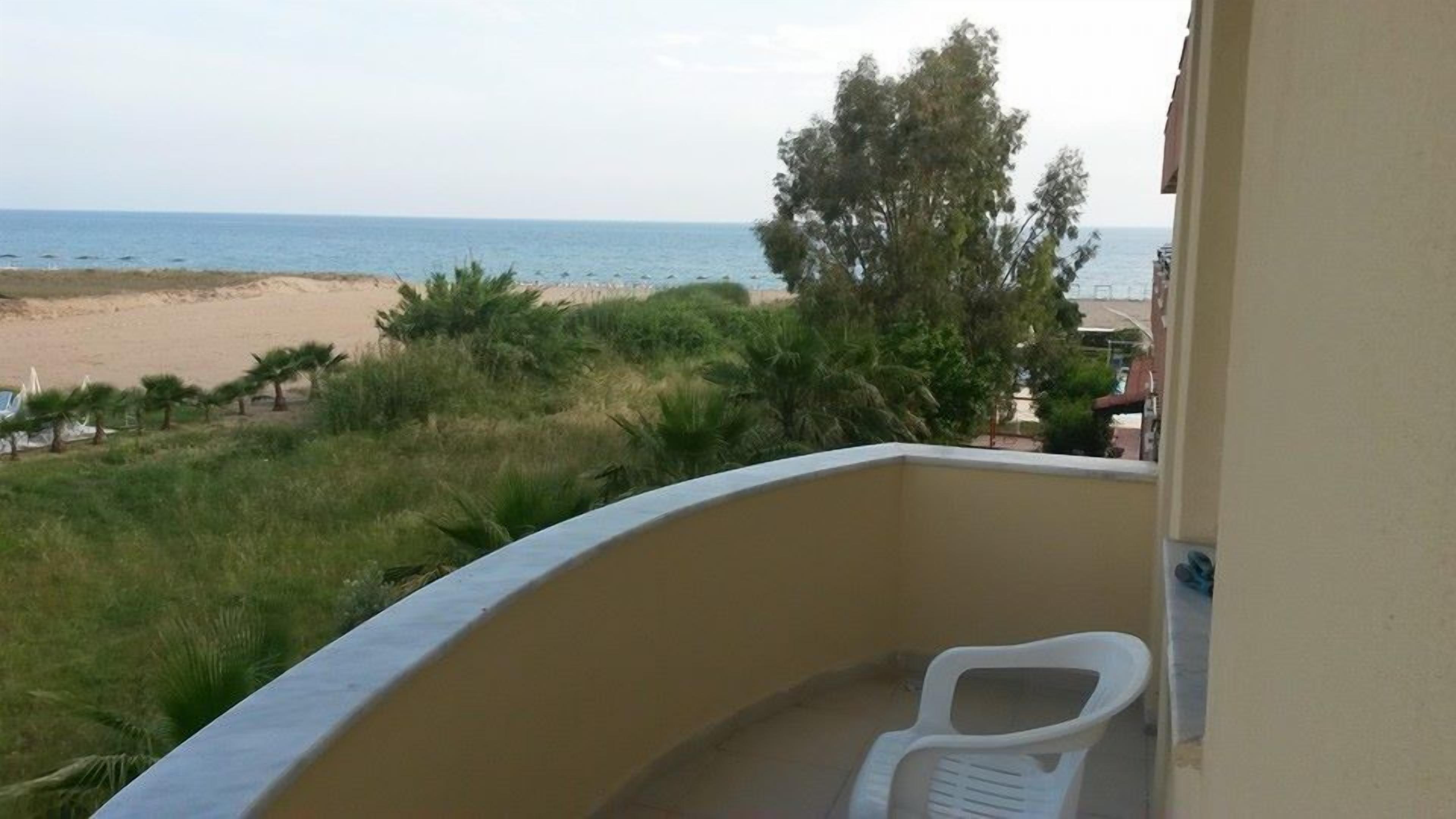 A balcony with a view of the beach and ocean.