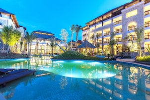 Una piscina al aire libre, sombrillas, sillones reclinables de piscina