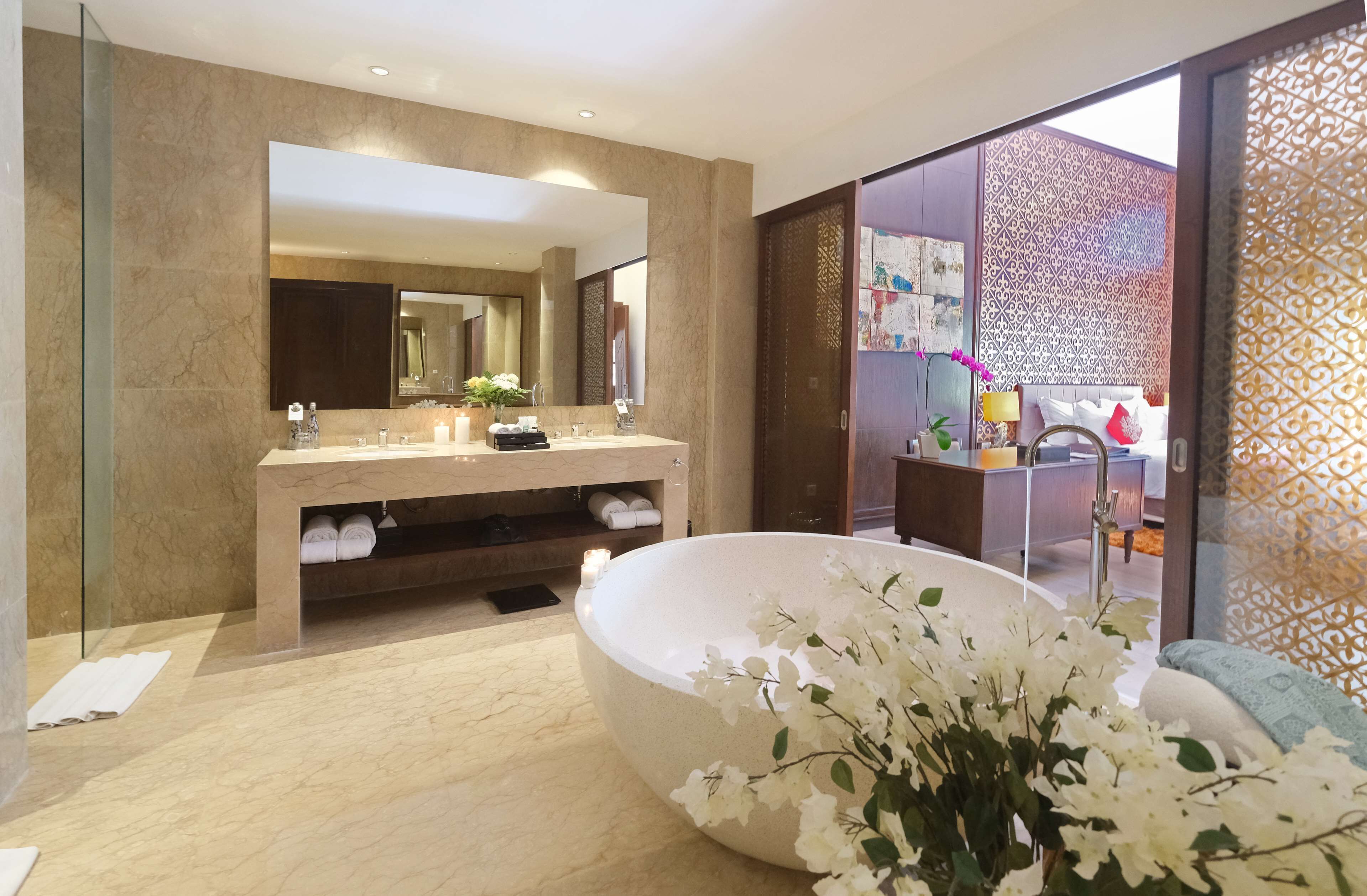 Un baño moderno con un espejo grande, una bañera y un tocador con lavabo.