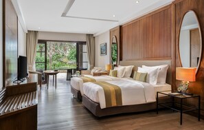A hotel room with a large bed, a TV, a desk, and a view of the outdoors. - Royal Tulip Springhill Resort Jimbaran (Jimbaran)