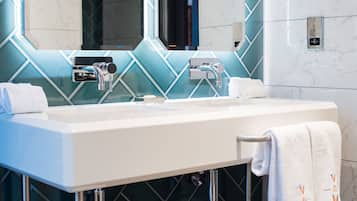 A modern bathroom with a dual sink, chrome faucets, and a mirror above.