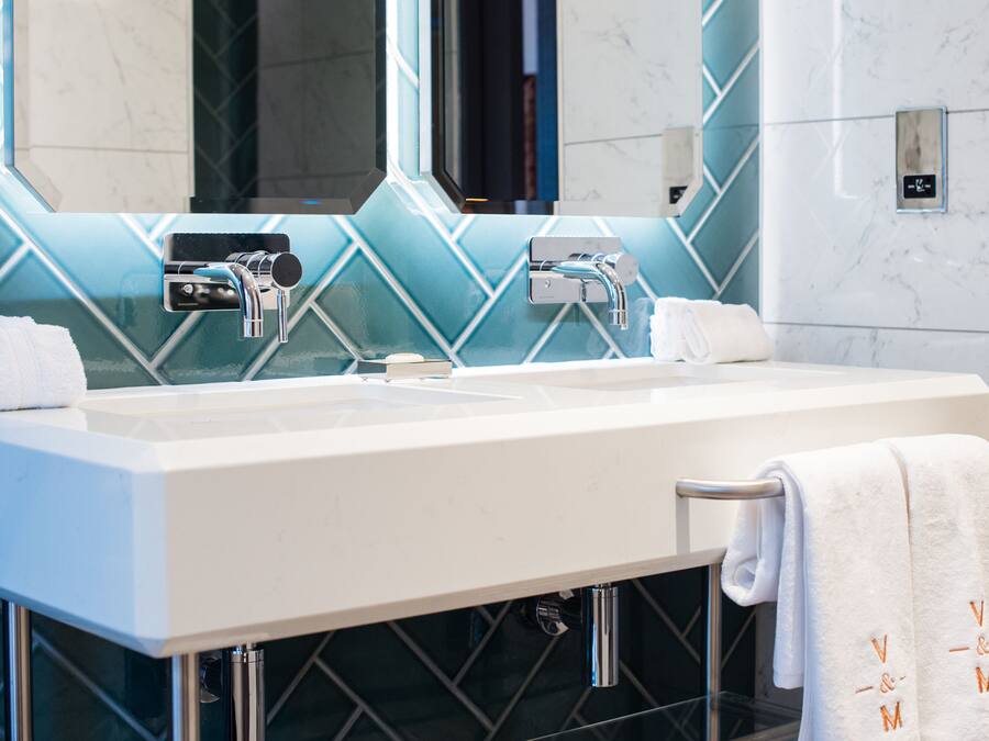 A modern bathroom with a dual sink, chrome faucets, and a mirror above.