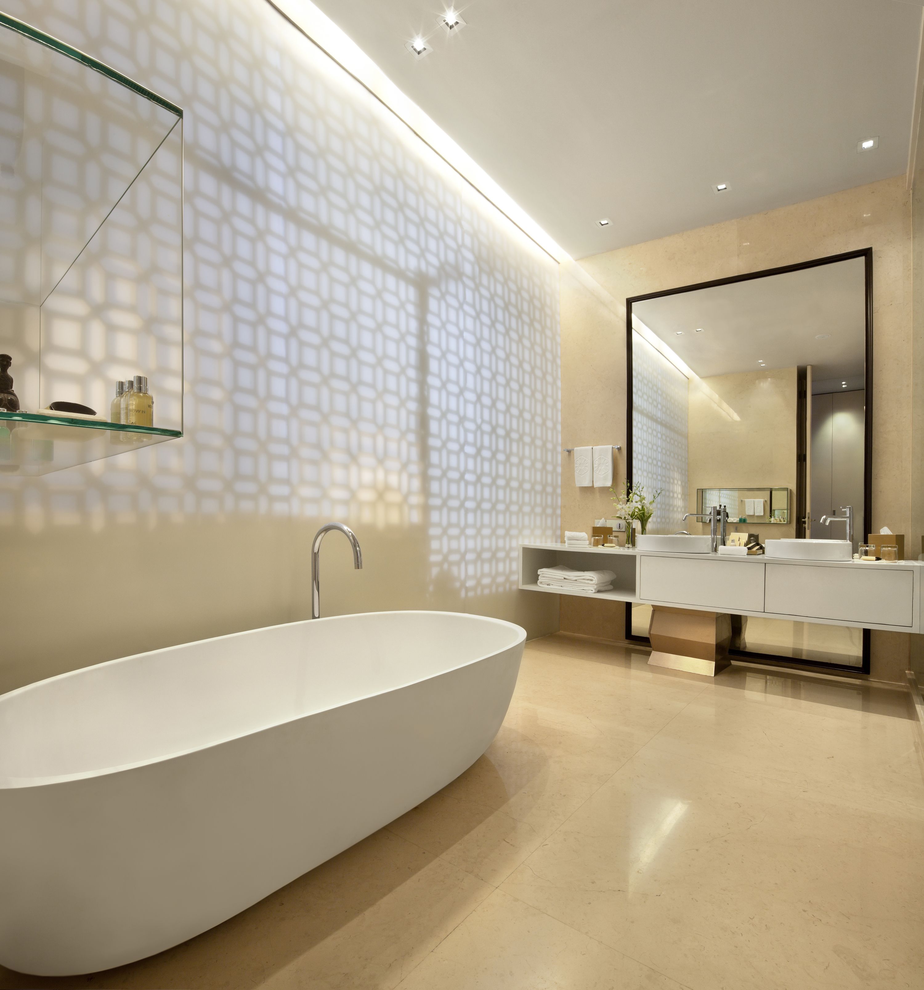 A modern bathroom with a freestanding bathtub, a large mirror, and a vanity with a sink.