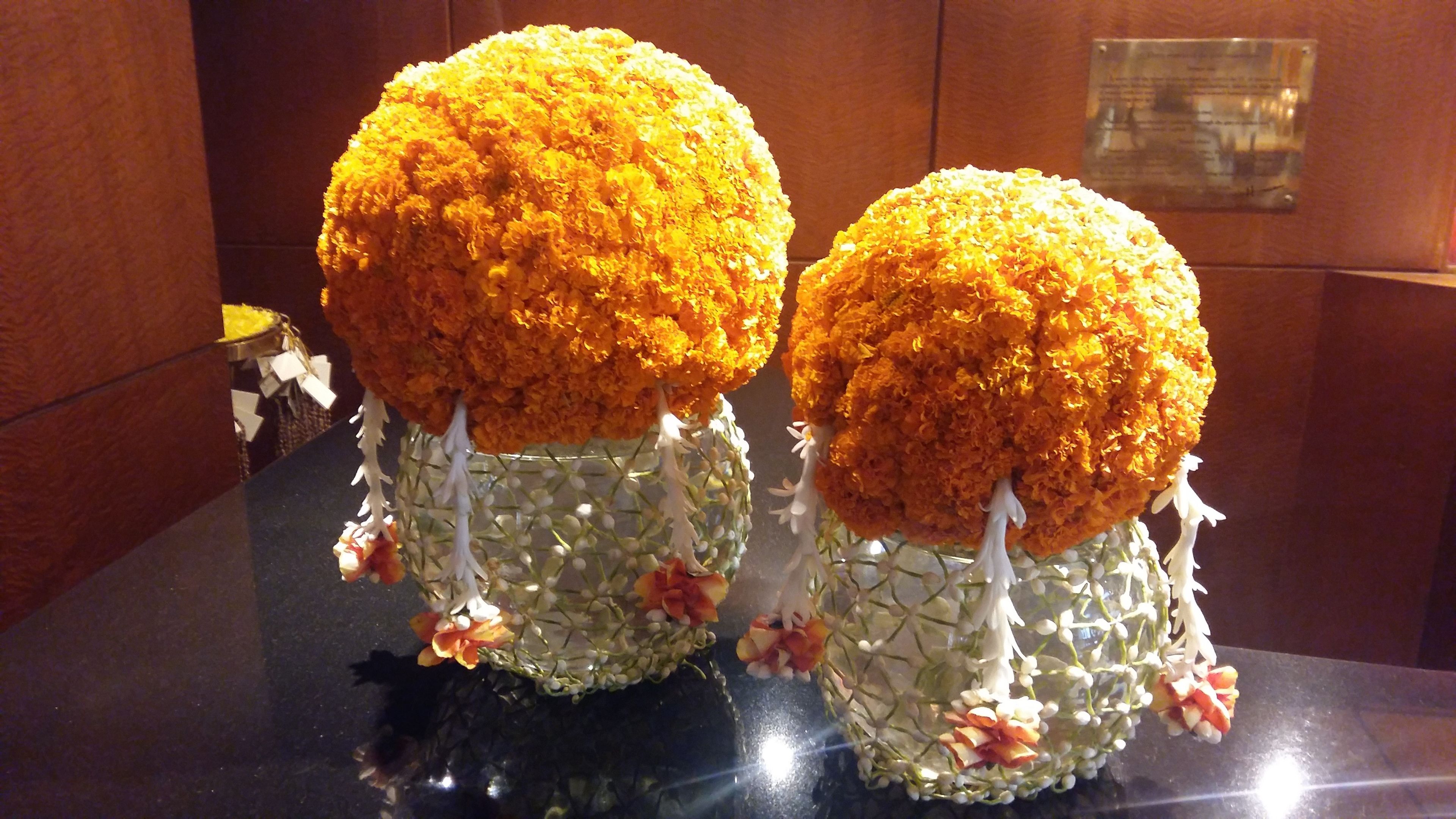 Two spherical objects with orange and white elements, placed on a reflective surface.